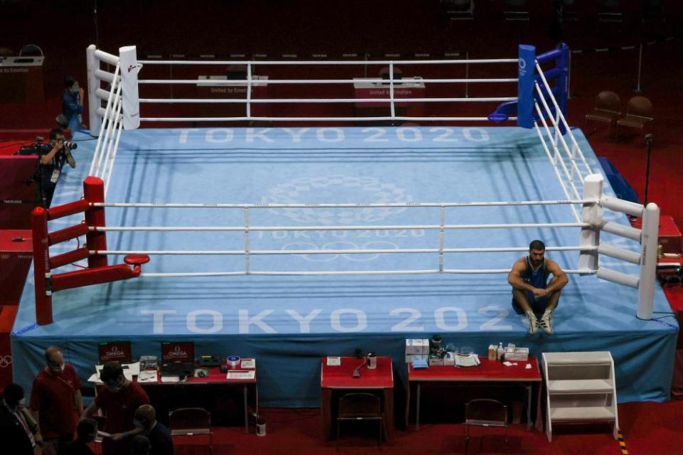 Mourad Aliev of France sits outside the ring in protest after the referee stopped his fight.