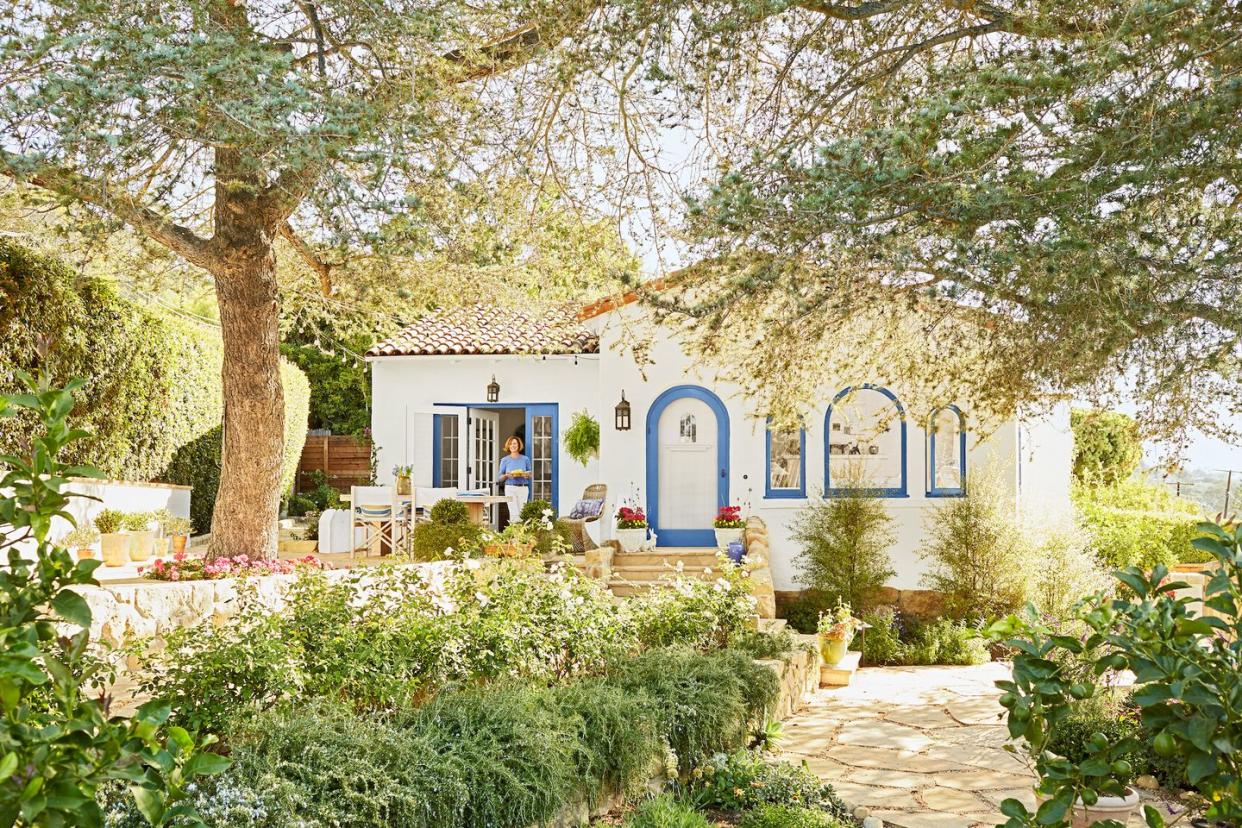 a house with a blue door and trees around it