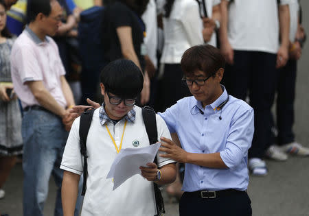 A representative of students who survived the April 16 ferry disaster cries while reading a letter as a teacher comforts him at Danwon Highschool in Ansan June 25, 2014. REUTERS/Kim Hong-Ji