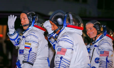 The International Space Station (ISS) crew members Joe Acaba (C) and Mark Vande Hei (R) of the the U.S., and Alexander Misurkin of Russia walk after donning space suits shortly before their launch at the Baikonur Cosmodrome, Kazakhstan September 13, 2017. REUTERS/Shamil Zhumatov