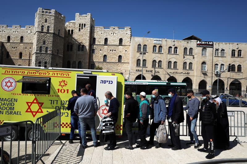 People queue to get vaccination against the coronavirus disease (COVID-19) at a mobile vaccination vehicle, in Jerusalem