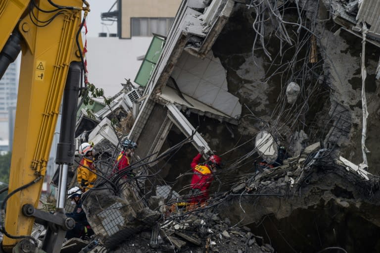 Rescue workers look for possible victims within the rubble of an apartment in one of the top floors of the Wei-Kuan complex that collapsed in the 6.4-magnitude earthquake, in Tainan on February 10, 2016