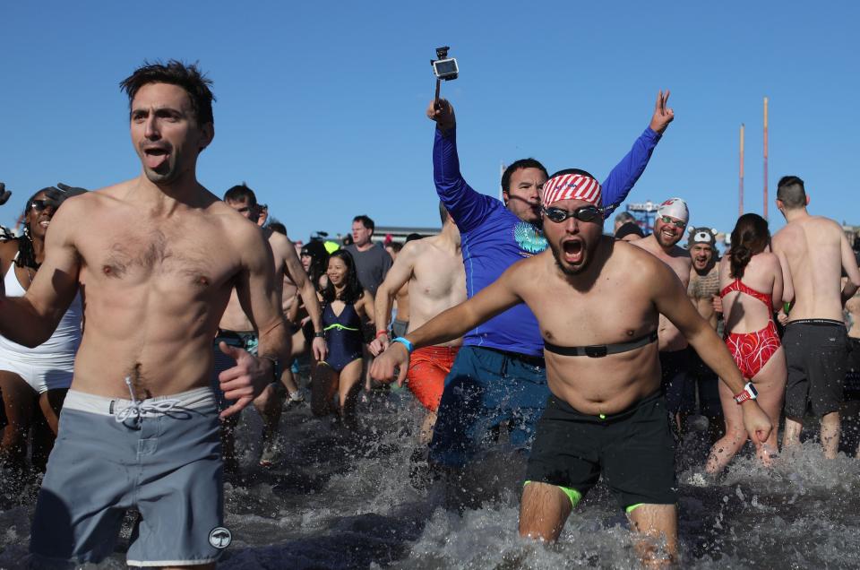 <p>Participants rush in the water during a polar bear plunge at the beach in Coney Island, Brooklyn on Jan. 1, 2018. New Yorkers took part in new year’s day swim with temperature standing at -7 degrees Celsius. (Photo: Atilgan Ozdil/Anadolu Agency/Getty Images) </p>