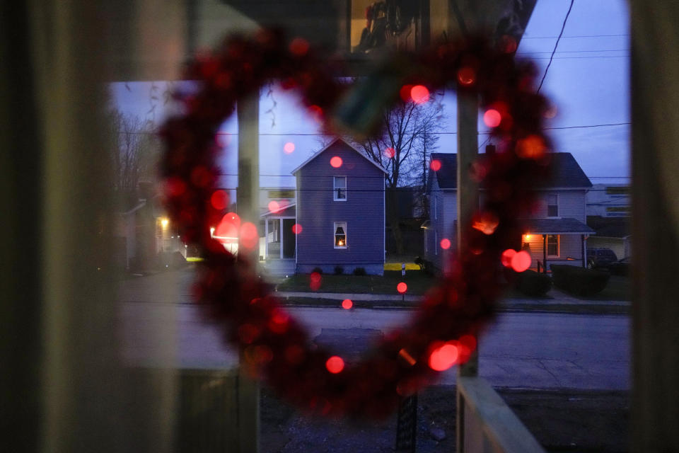 A heart with lights hangs in the front door of Sam Chirico's home in East Palestine, Ohio, on Tuesday, Jan. 30, 2024, as a train passes behind the homes across the street. Daily life largely returned to normal for residents of East Palestine, Ohio, months after a Norfolk Southern train derailed and spilled a cocktail of hazardous chemicals that caught fire a year ago, but the worries and fears are always there. (AP Photo/Carolyn Kaster)