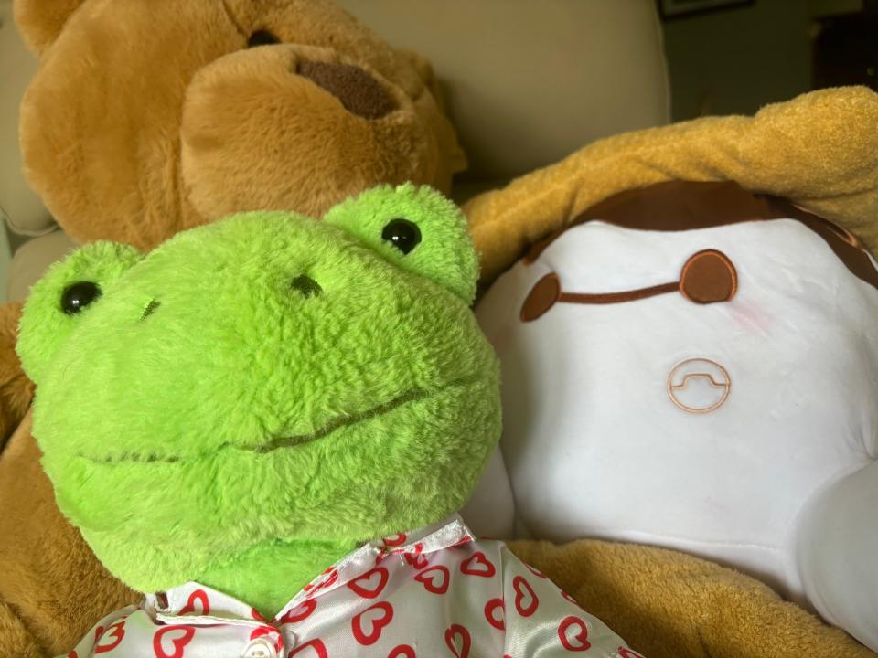 A green Build-A-Bear frog plush, a Disney Munchlings Baymax plush, and a teddy bear from an unknown brand.