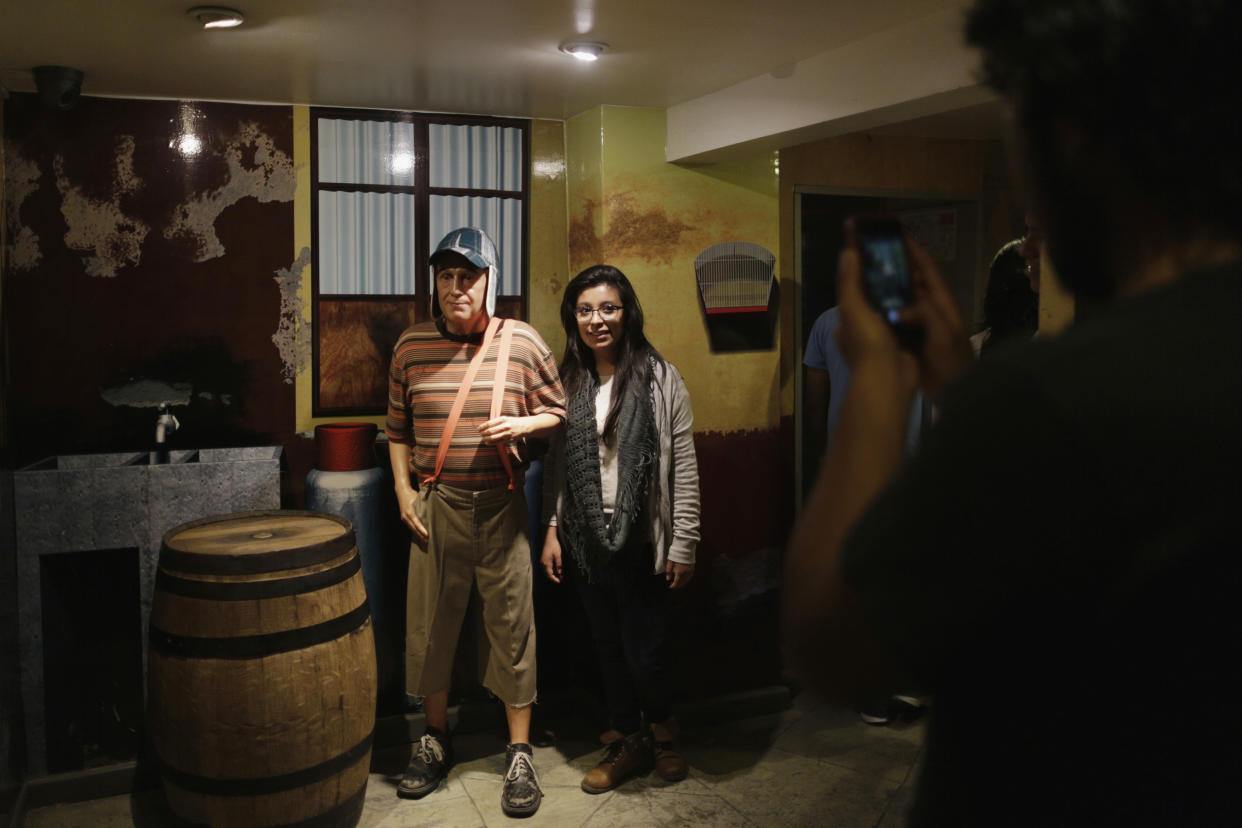 A visitor poses next to a wax figure of El Chavo del Ocho, portrayed by comedian Roberto Gomez Bolanos at the wax museum in Mexico City November 28, 2014. Mexican actor and screenwriter Gomez Bolanos, one of Latin America's most beloved comedians, whose slapstick acts charmed fans from Spain to Argentina for over four decades, died on Friday at the age 85. Known as 