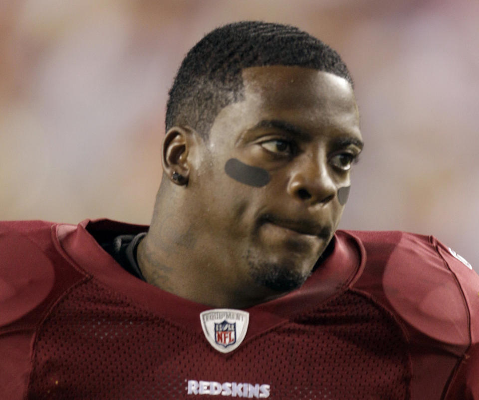 FILE - This Sept. 12, 2010, file photo shows Washington Redskins running back Clinton Portis before the start of an NFL football game against the Dallas Cowboys, in Landover, Md. Ten former NFL players have been charged with defrauding the league’s healthcare benefit program. They include five who played on the Washington Redskins, including Clinton Portis and Carlos Rogers. (AP Photo/Rob Carr, File)