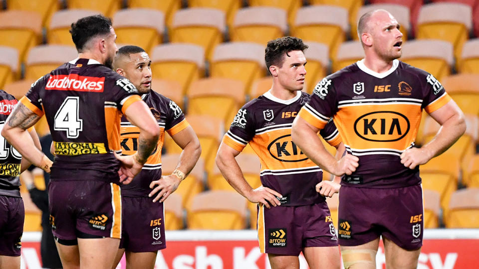 Pictured here, Broncos players look on in sadness after being hammered by the Roosters.