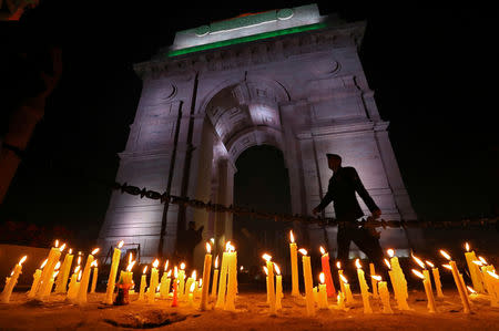 A soldier walks during a candle light vigil to pay tribute to Central Reserve Police Force (CRPF) personnel who were killed after a suicide bomber rammed a car into the bus carrying them in south Kashmir on Thursday, in front of India Gate war memorial in New Delhi, February 16, 2019. REUTERS/Anushree Fadnavis