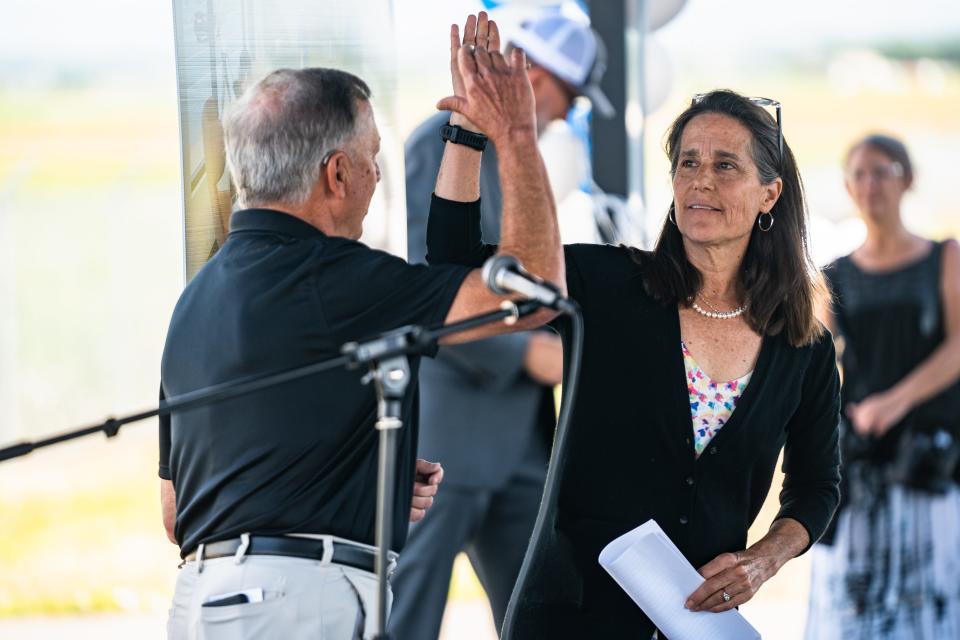 Fort Collins Mayor Jeni Arndt high fives Don Overcash during a groundbreaking ceremony for a new terminal at the Northern Colorado Regional Airport on Thursday, July 13, 2023, in Loveland, Colo.
