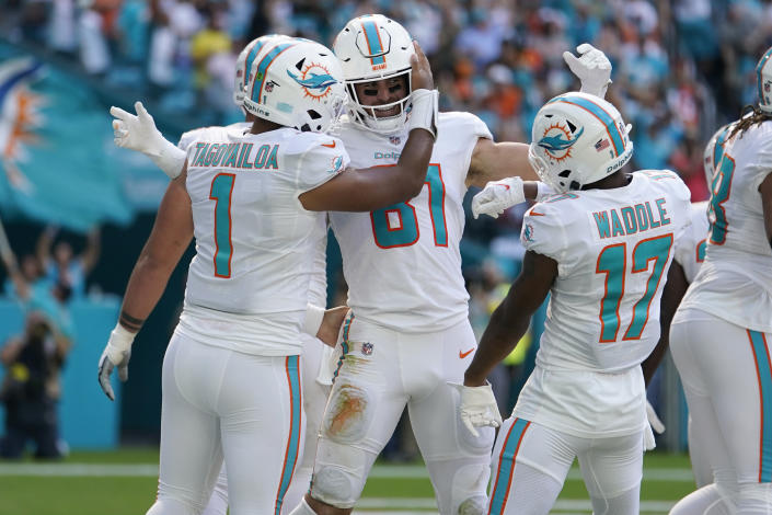 Miami Dolphins tight end Durham Smythe (81) is congratulated by quarterback Tua Tagovailoa (1) and wide receiver Jaylen Waddle (17) after Carter scored a touchdown during the first half of an NFL football game against the Houston Texans, Sunday, Nov. 27, 2022, in Miami Gardens, Fla. (AP Photo/Lynne Sladky)