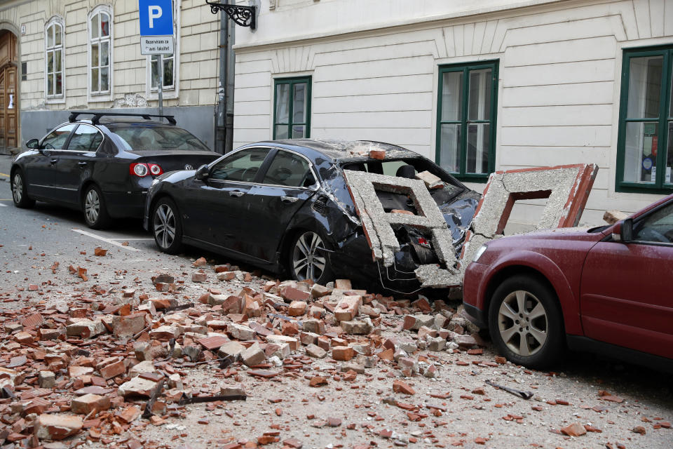 A car is crushed by falling debris after an earthquake in Zagreb, Croatia, Sunday, March 22, 2020. A strong earthquake shook Croatia and its capital on Sunday, causing widespread damage and panic.(AP Photo/Darko Bandic)