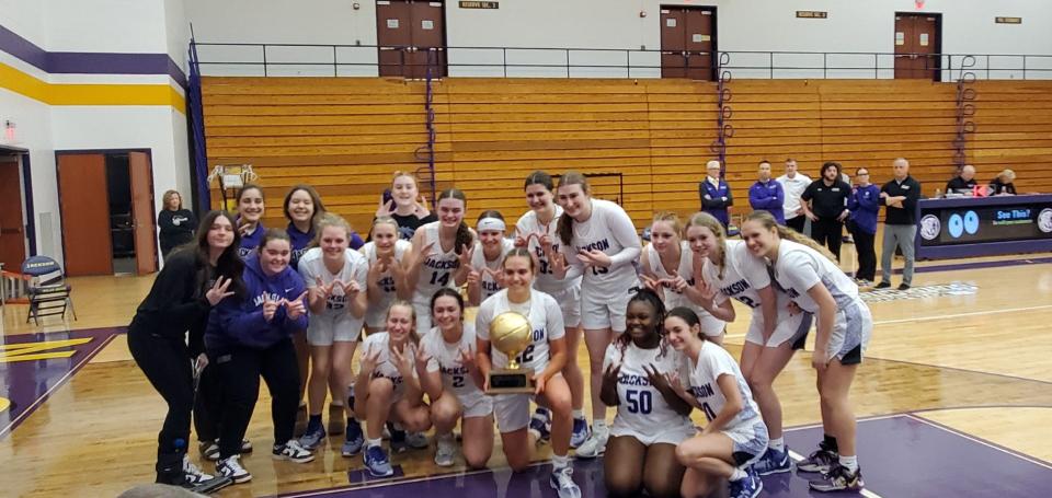 The Jackson High School girls basketball takes a team photo after defeating Perry, 52-43, to clinch a share of the Federal League title on Saturday, Feb. 2.