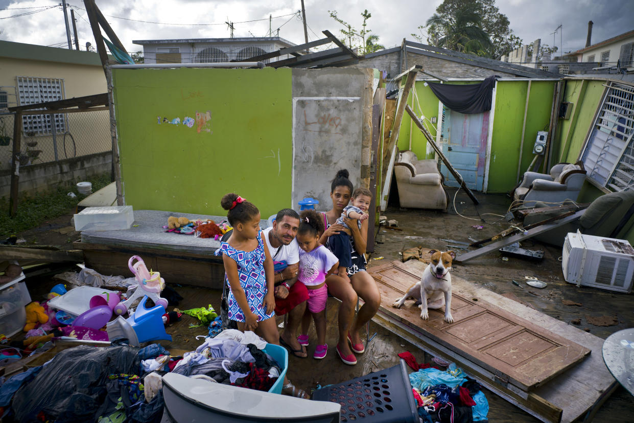 In this photo from October, Arden Dragoni, second from left, poses with his wife, Sindy, their three children and dog Max, surrounded by what remains of their home destroyed by Hurricane Maria in Toa Baja, Puerto Rico. (Photo: Ramon Espinosa/AP)