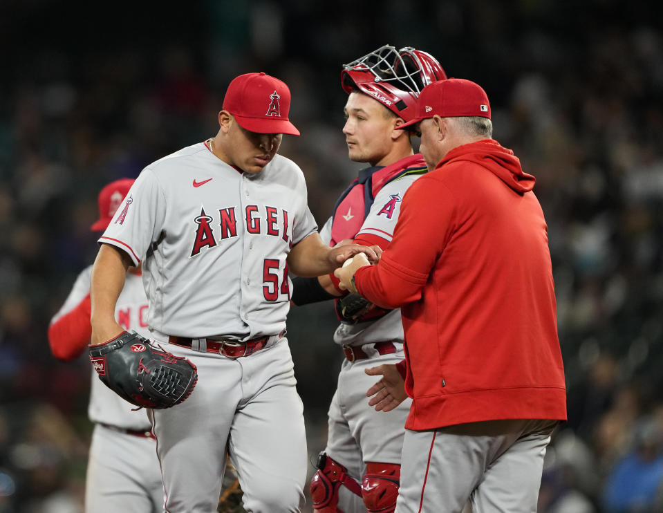 Los Angeles Angels starting pitcher Jose Suarez is taken out of the game by manager Phil Kevin, right, as catcher Matt Thaiss, center, looks on during the fifth inning of a baseball game against the Seattle Mariners, Tuesday, April 4, 2023, in Seattle. (AP Photo/Lindsey Wasson)