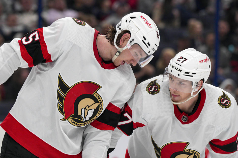 Ottawa Senators' Jake Sanderson, left, speaks with Parker Kelly during the second period of an NHL hockey game against the Columbus Blue Jackets Thursday, March 14, 2024, in Columbus, Ohio. (AP Photo/Jeff Dean)
