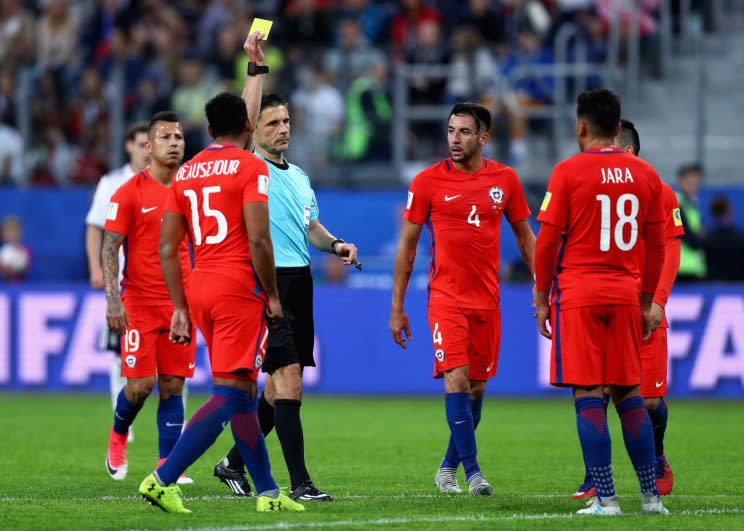 Chile man Gonzalo Jara is booked after the referee uses VAR