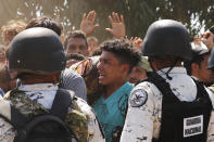 Central American migrants who crossed the Suchiate River from Guatemala to Mexico are stopped by Mexican National Guard on the riverbank near Ciudad Hidalgo, Mexico, Monday, Jan. 20, 2020. More than a thousand Central American migrants hoping to reach the United States marooned in Guatemala are walking en masse across a river leading to Mexico in an attempt to convince authorities there to allow them passage through the country. (AP Photo/Marco Ugarte)