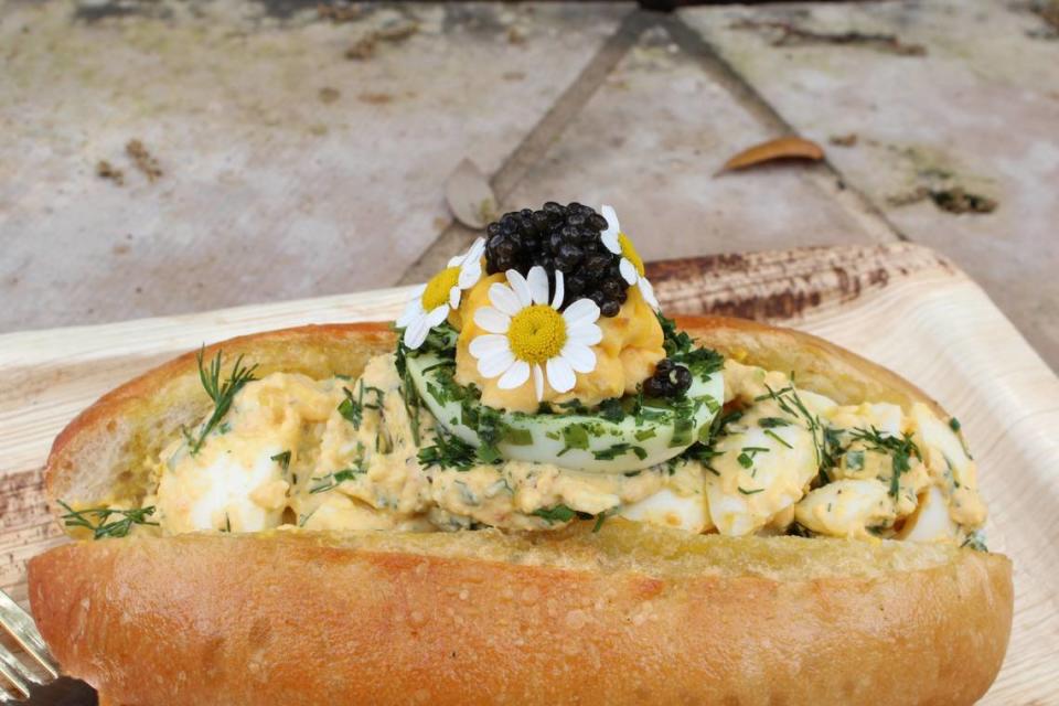 Luckybee Kitchen’s caviar and deviled egg sandwich is filled with egg salad and topped with Osetra caviar and dill on a toasty bun with a side of potato chips.