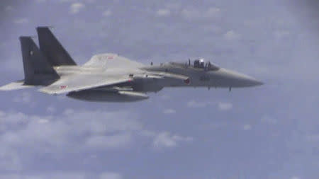 A Japanese F-15 military plane flies over the East China Sea, in this still image from video footage released by China's Ministry of Defense on June 12, 2014. China said on Thursday that Japan's accusations of Chinese fighter jets flying "abnormally close" to Japanese military aircraft over the East China Sea were aimed at deceiving the international community. REUTERS/Ministry of National Defense of the People's Republic of China/via Reuters TV