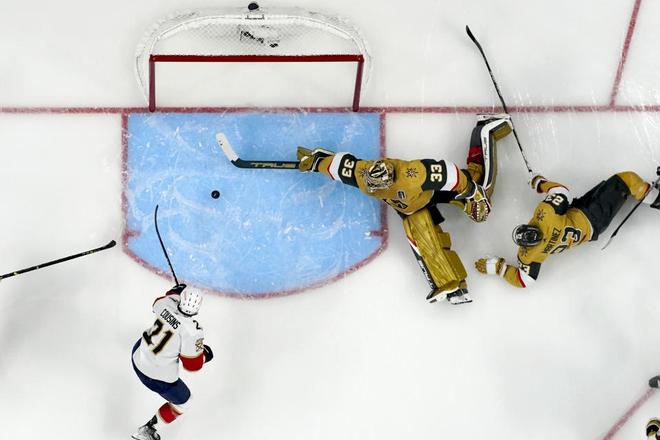 Vegas Golden Knights goaltender Adin Hill (33) blocks a shot on goal by Florida Panthers center Nick Cousins (21) during the second period of Game 1 of the NHL hockey Stanley Cup Finals, Saturday, June 3, 2023, in Las Vegas. (AP Photo/John Locher)