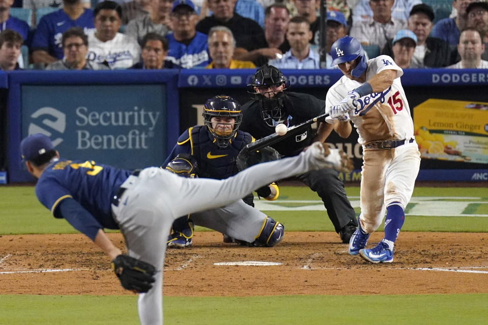 Los Angeles Dodgers' Austin Barnes, right, hits a solo home run as Milwaukee Brewers relief pitcher Joel Payamps, left, watches along with catcher Victor Caratini, second from left, and home plate umpire Chris Guccione during the eighth inning of a baseball game Thursday, Aug. 17, 2023, in Los Angeles. (AP Photo/Mark J. Terrill)