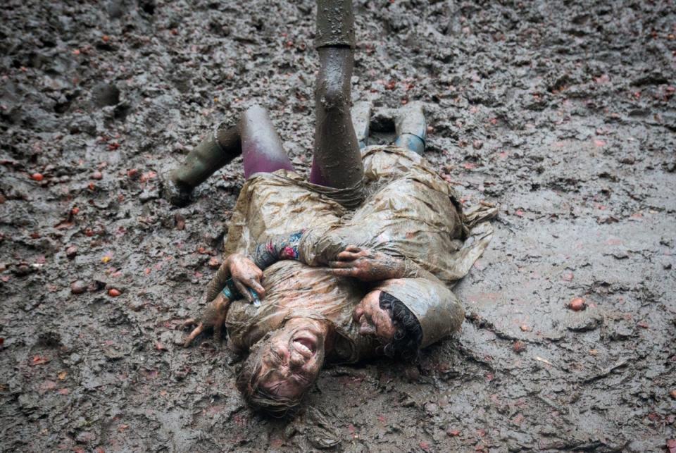 Two festival revellers roll in the mud after they took part in a tomato fight in 2016 (Getty Images)