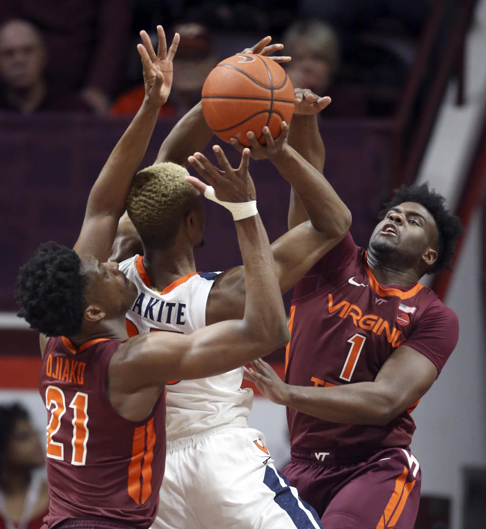 Virginia's Mamadi Diakite (25) has his shot blocked as Virginia Tech's Isaiah Wilkins (1) and John Ojiako (21) defend during the first half of an NCAA college basketball game Wednesday, Feb. 26, 2020, in Blacksburg, Va. (Matt Gentry/The Roanoke Times via AP)