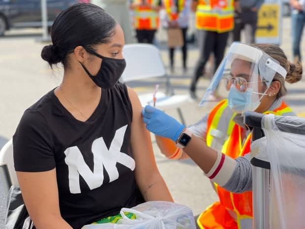 A person receives a COVID-19 vaccine dose through the Vax Van, a mobile vaccination clinic run by Peel Region, at Westwood Square Mall in Mississauga on Sept. 16, 2021. (Chris Glover/CBC - image credit)