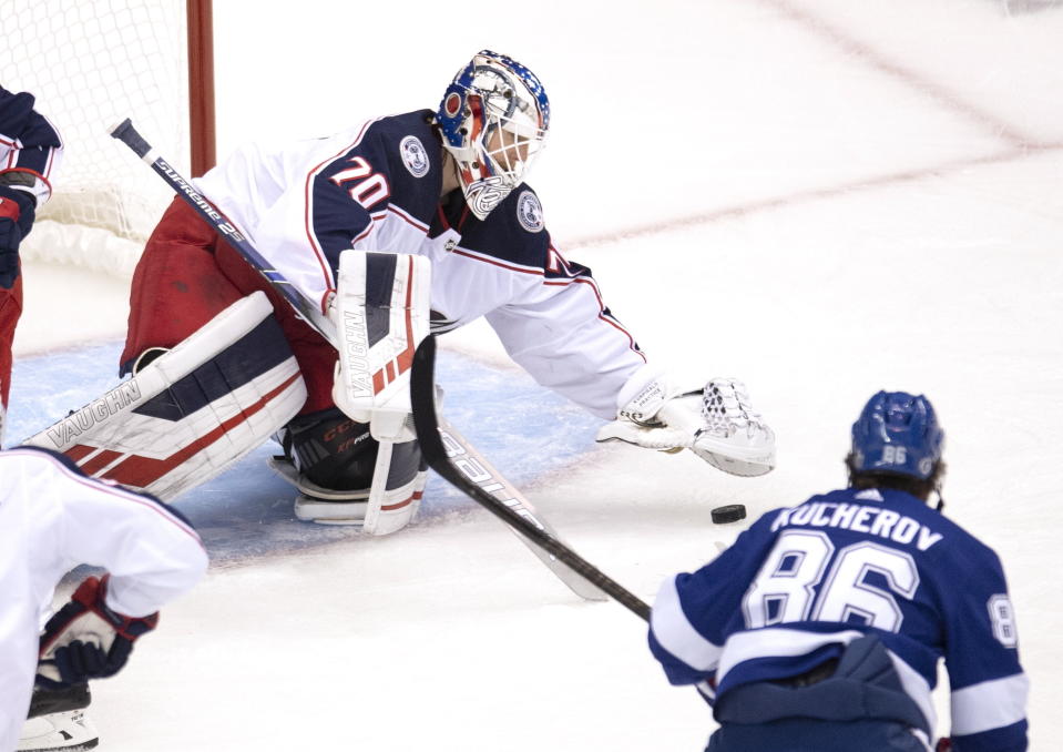 Columbus Blue Jackets goaltender Joonas Korpisalo (70) covers the puck under pressure from Tampa Bay Lightning right wing Nikita Kucherov (86) during the first period in Game 1 of an NHL hockey Stanley Cup first-round playoff series, Tuesday, Aug. 11, 2020, in Toronto. (Frank Gunn/The Canadian Press via AP)