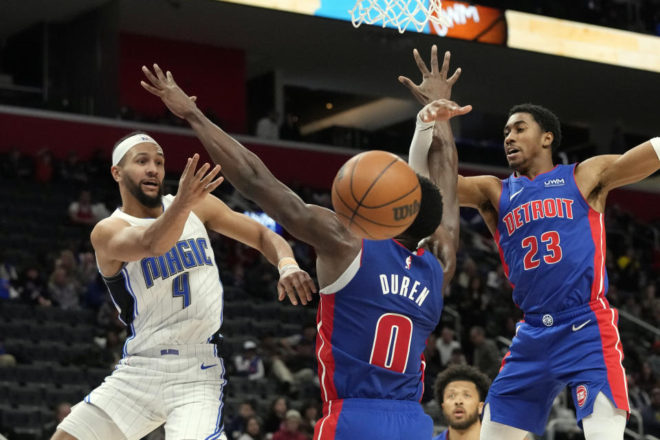 Orlando Magic guard Jalen Suggs (4) passes the ball as Detroit Pistons center Jalen Duren (0) defends during the second half of an NBA basketball game, Saturday, Feb. 24, 2024, in Detroit. (AP Photo/Carlos Osorio)