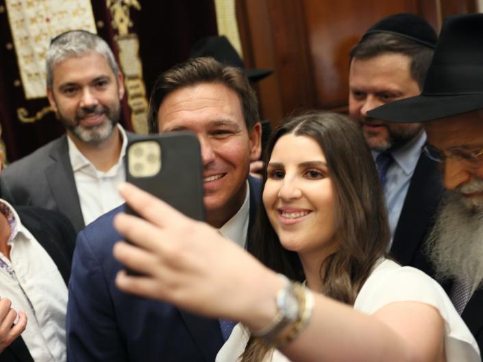 Florida Gov. Ron DeSantis greets Rose Simhon after signing two bills at the Shul of Bal Harbour on June 14, 2021 in Surfside, Florida. The bills are HB 529 and HB 805. HB 805 ensures that volunteer ambulance services, including Hatzalah, can operate. HB 529 requires Florida schools to hold a daily moment of silence.