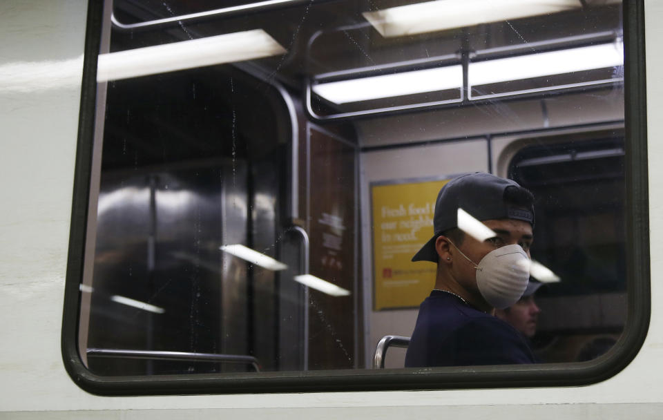 BOSTON, MA - MARCH 25: An MBTA passenger wears a protective face mask as he rides the train at the Government Center T station on March 25, 2020. Gov. Charlie Baker this week issued a stay-at-home advisory for non-essential workers to reduce the spread of coronavirus. (Photo by Jessica Rinaldi/The Boston Globe via Getty Images)