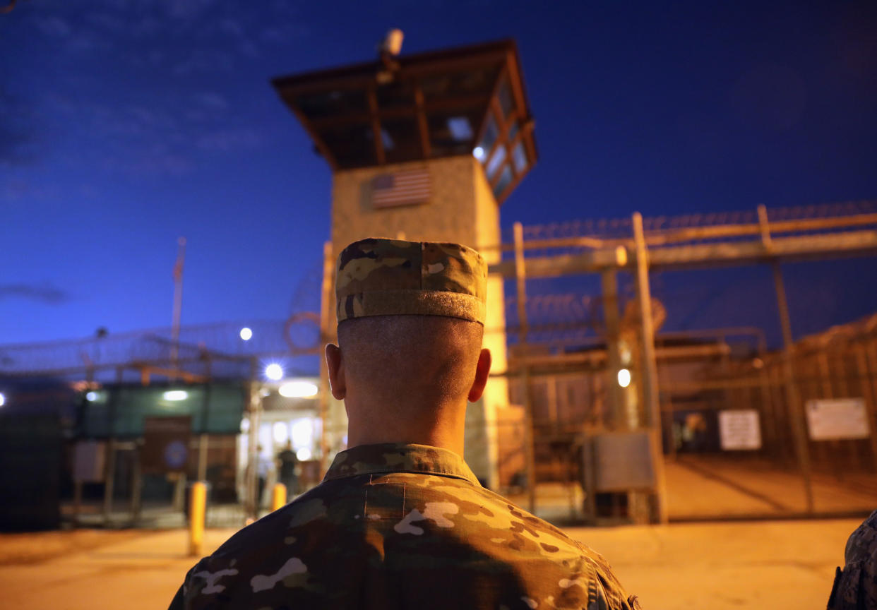 A U.S. Army soldier, seen from behind, stands outside the detention center at Naval Station Guantánamo Bay, Cuba.