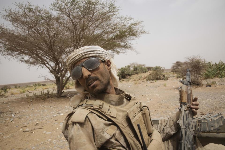 A Yemeni fighter backed by the Saudi-led coalition rides on the back of an armored vehicle as he leaves the front lines of Marib, Yemen, Saturday, June 19, 2021. (AP Photo/Nariman El-Mofty)