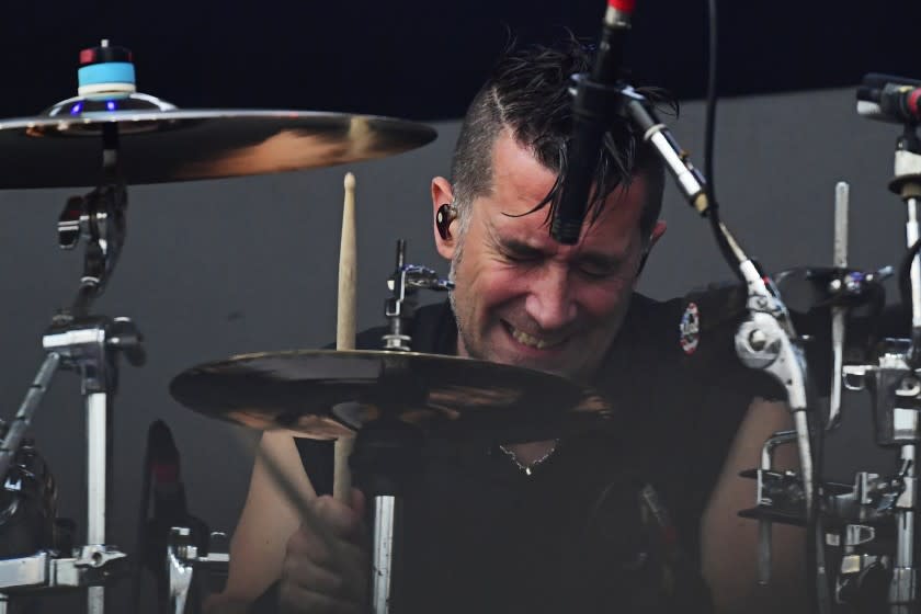 A man plays vigorously on a drum kit