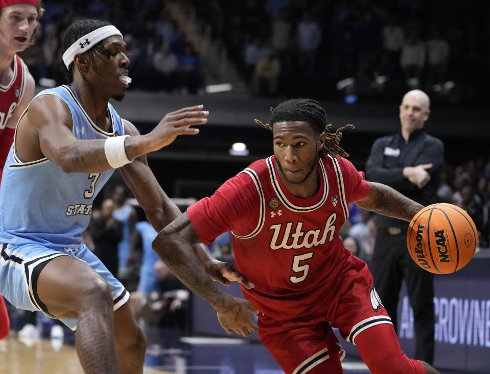 FILE - Utah guard Deivon Smith (5) drives past Indiana State guard Ryan Conwell (3) in the second half of an NCAA college basketball game in the semifinals of the NIT, April 2, 2024, in Indianapolis. Smith is transferring to St. John’s from Utah, giving Hall of Fame coach Rick Pitino a veteran replacement for Daniss Jenkins next season. (AP Photo/Michael Conroy, File)