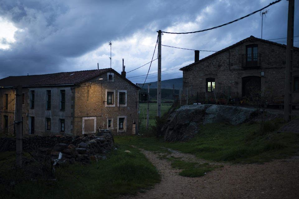 In this April 27, 2020 photo, homes are illuminated at dusk in Duruelo de la Sierra, Spain, in the province of Soria. Many in Spain's small and shrinking villages thought their low populations would protect them from the coronavirus pandemic. The opposite appears to have proved true. Soria, a north-central province that's one of the least densely peopled places in Europe, has recorded a shocking death rate. Provincial authorities calculate that at least 500 people have died since the start of the outbreak in April. (AP Photo/Felipe Dana)