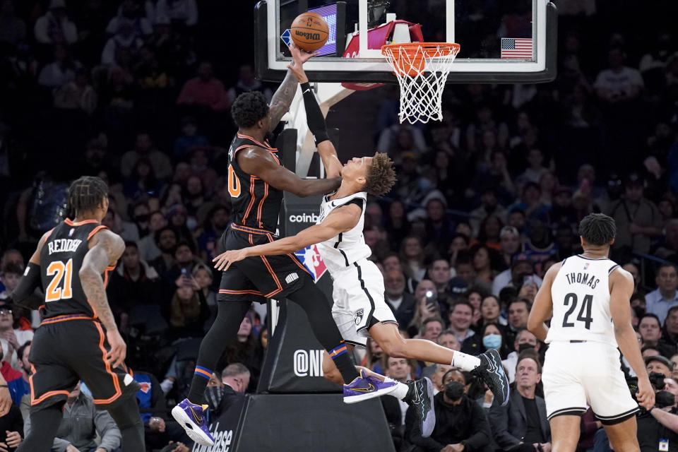 New York Knicks forward Julius Randle, center left, scores against Brooklyn Nets forward Kessler Edwards, center right, during the first half of an NBA basketball game, Wednesday, Feb. 16, 2022, in New York. (AP Photo/John Minchillo)