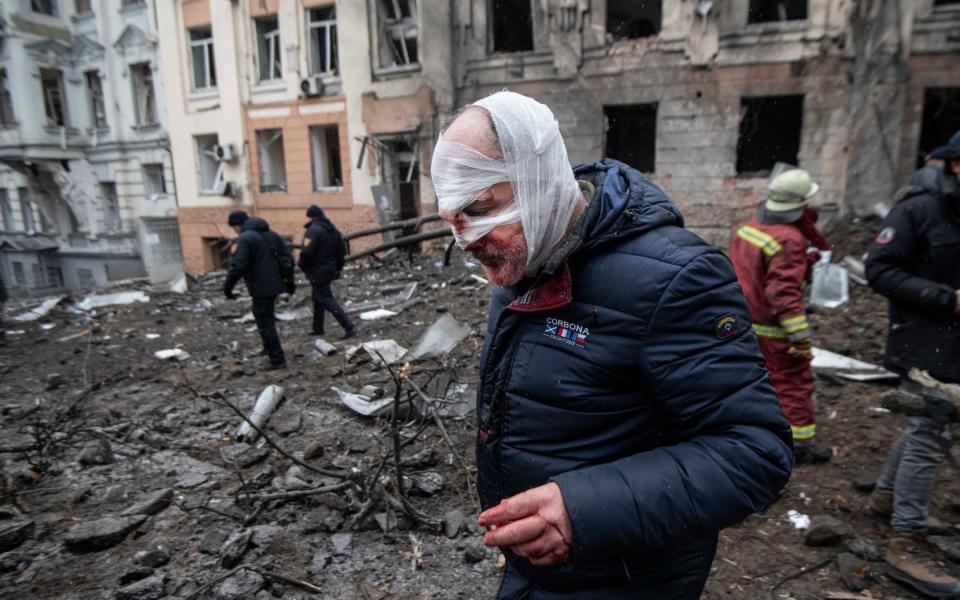 Injured residents are evacuated from the scene of the missile strikes in central Kharkiv - Julian Simmonds for The Telegraph