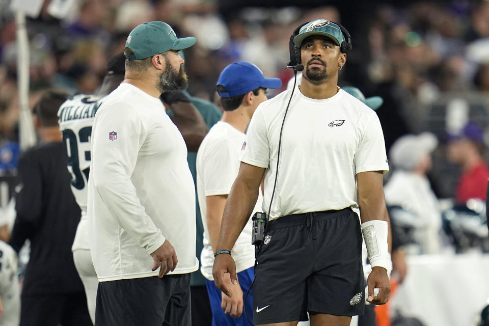 Philadelphia Eagles center Jason Kelce, left, and quarterback Jalen Hurts watch from the sideline during the first half of an NFL preseason football game against the Baltimore Ravens in Baltimore, Saturday, Aug. 12, 2023. (AP Photo/Julio Cortez)