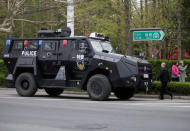 Residents walk past a police armoured vehicle near a media center for marking the 70th anniversary of the founding of the Chinese People's Liberation Army Navy, in Qingdao, China, April 20, 2019. REUTERS/Jason Lee