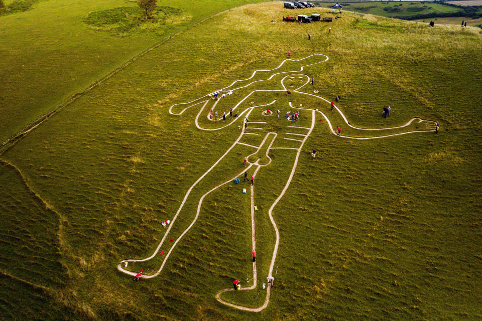 Volunteers work to repair and refresh the ancient Cerne Abbas Giant in Dorset, England. (Photo: Ben Birchall - PA Images via Getty Images)