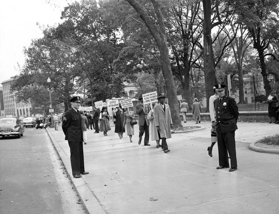 Officers stands by as black religious leaders from Chicago demonstrate outside the White House in Washington against the murder of 14-year-old Chicagoan boy Emmett Louis Till, on October 24, 1955. 