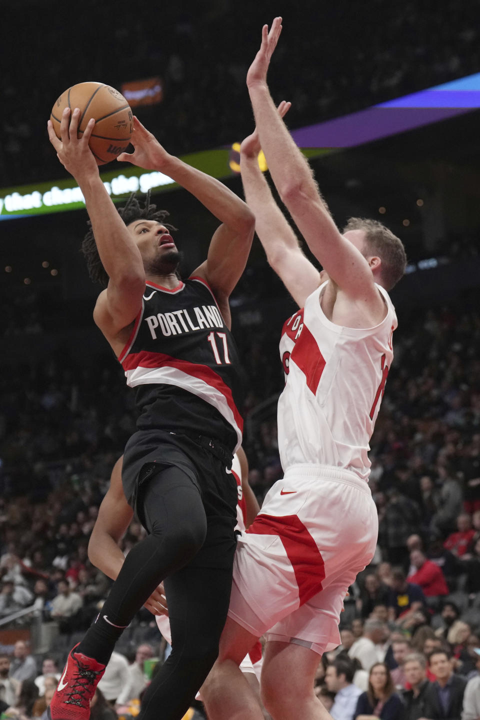 Portland Trail Blazers guard Shaedon Sharpe (17) shoots over Toronto Raptors center Jakob Poeltl, right, during second-half NBA basketball game action in Toronto, Monday, Oct. 30, 2023. (Nathan Denette/The Canadian Press via AP)