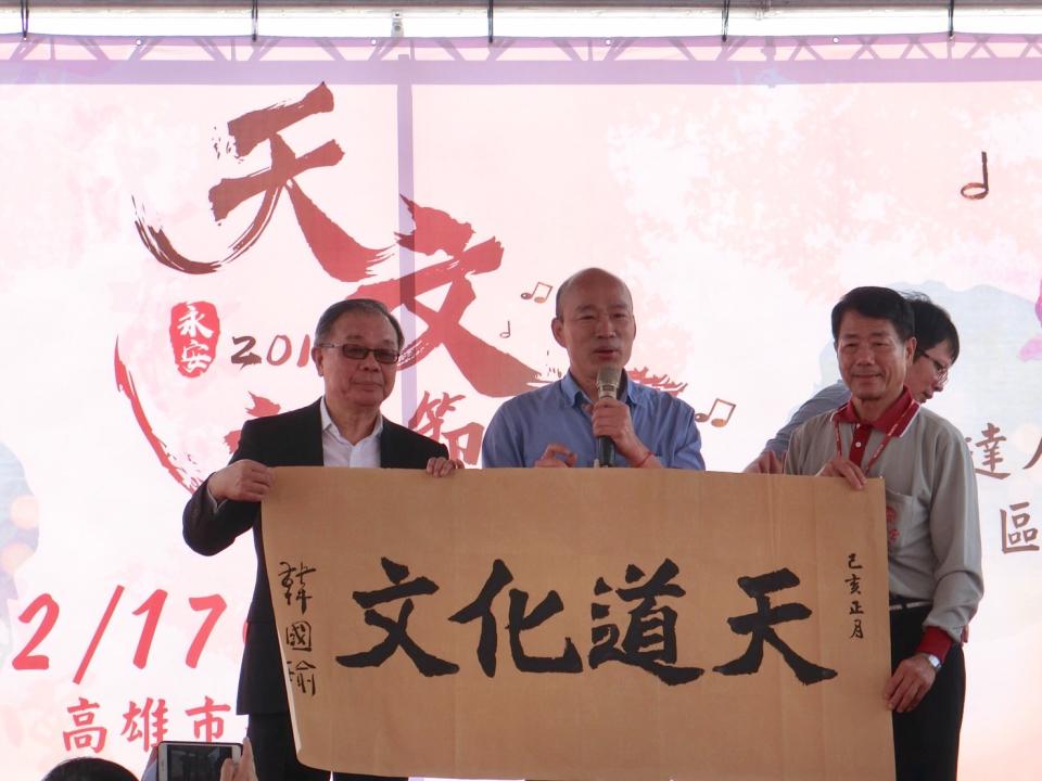 韓國瑜(左二)在廟方準備的「天道化文」題字上落款。   圖：高雄市新聞局／提供