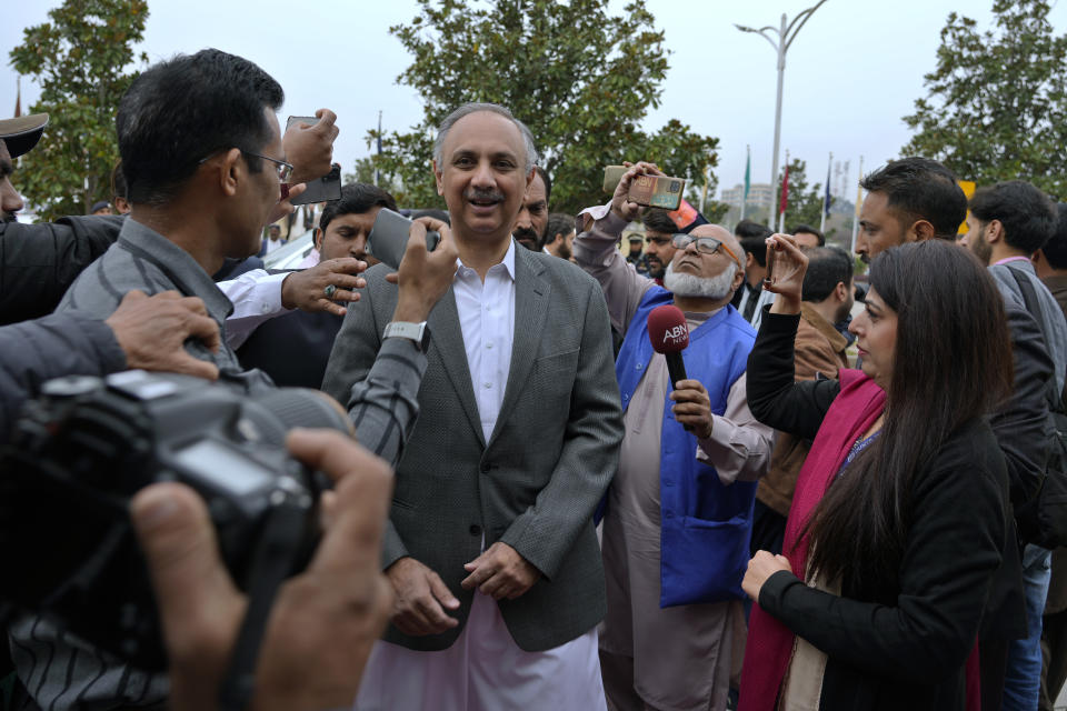 Omar Ayub, center, Pakistan's newly elected lawmaker from imprisoned former Prime Minister Imran Khan's party and candidate for Prime Minister of Pakistan, is surrounded by members of the media as he arrives to attend the opening session of parliament, in Islamabad, Pakistan, Thursday, Feb. 29, 2024. Pakistan's National Assembly swore in newly elected members on Thursday in a chaotic scene, as allies of jailed former Premier Khan protested what they claim was a rigged election. (AP Photo/Anjum Naveed)