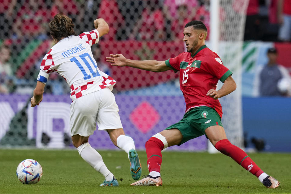 Croatia's Luka Modric (10) runs with the ball against Morocco's Selim Amallah (15) during the World Cup group F soccer match between Morocco and Croatia, at the Al Bayt Stadium in Al Khor , Qatar, Wednesday, Nov. 23, 2022. (AP Photo/Themba Hadebe)