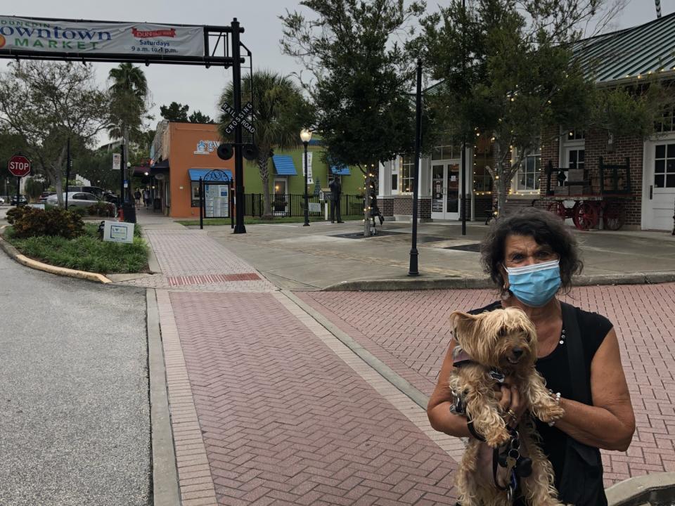 Melody Urso holds her dog, Rosie, as they pause while taking a walk in Dunedin, Fla.