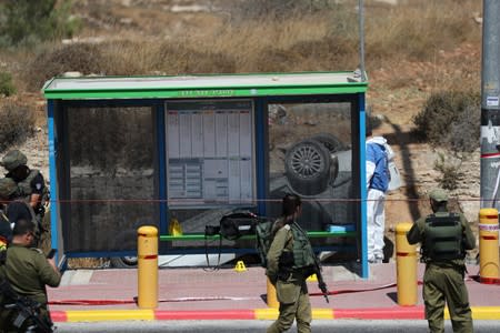 Israeli forces stand guard at the scene of what Israeli military said is a car-ramming attack near the settlement of Elazar in the Israeli-occupied West Bank